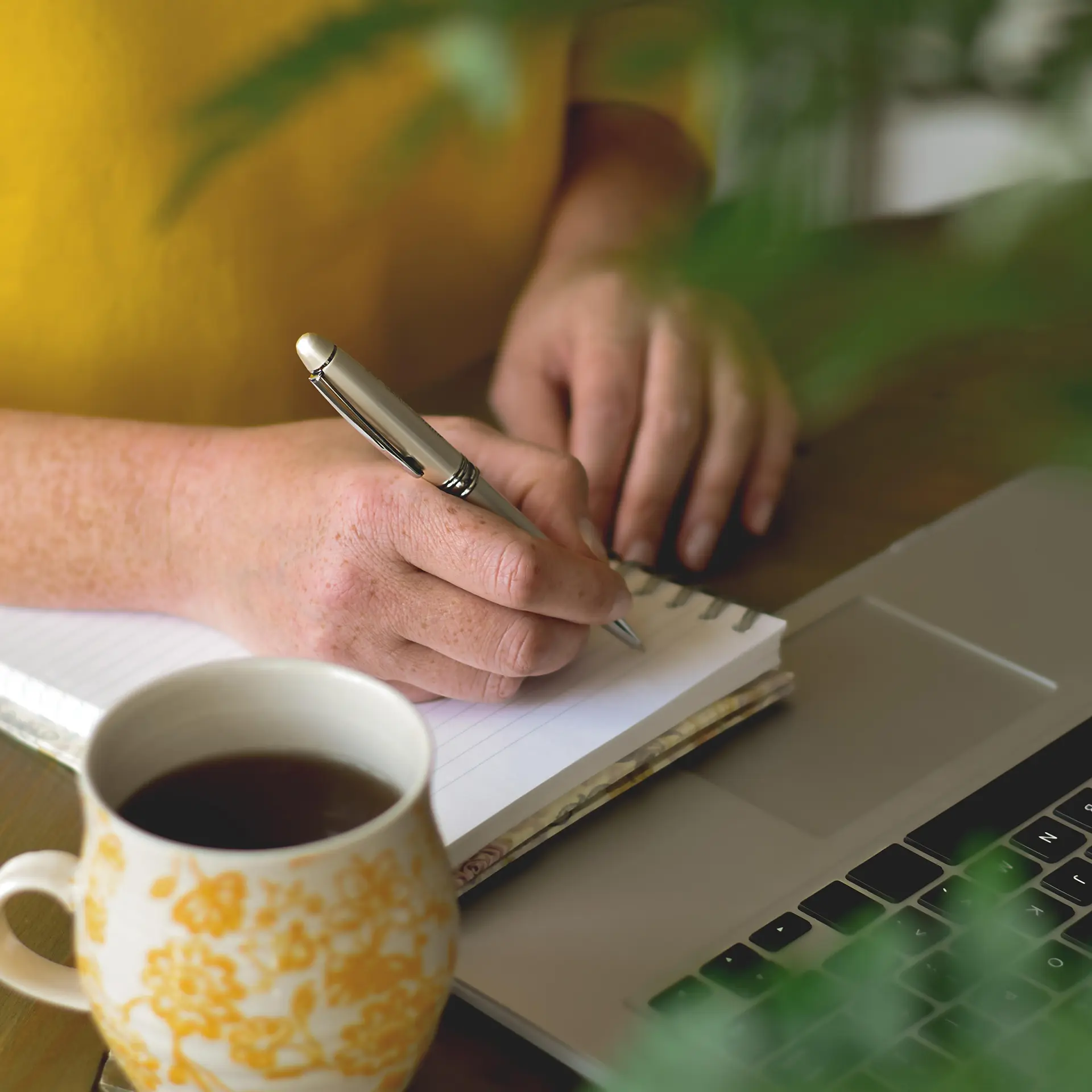 Woman writes in a notepad. Close-up.
